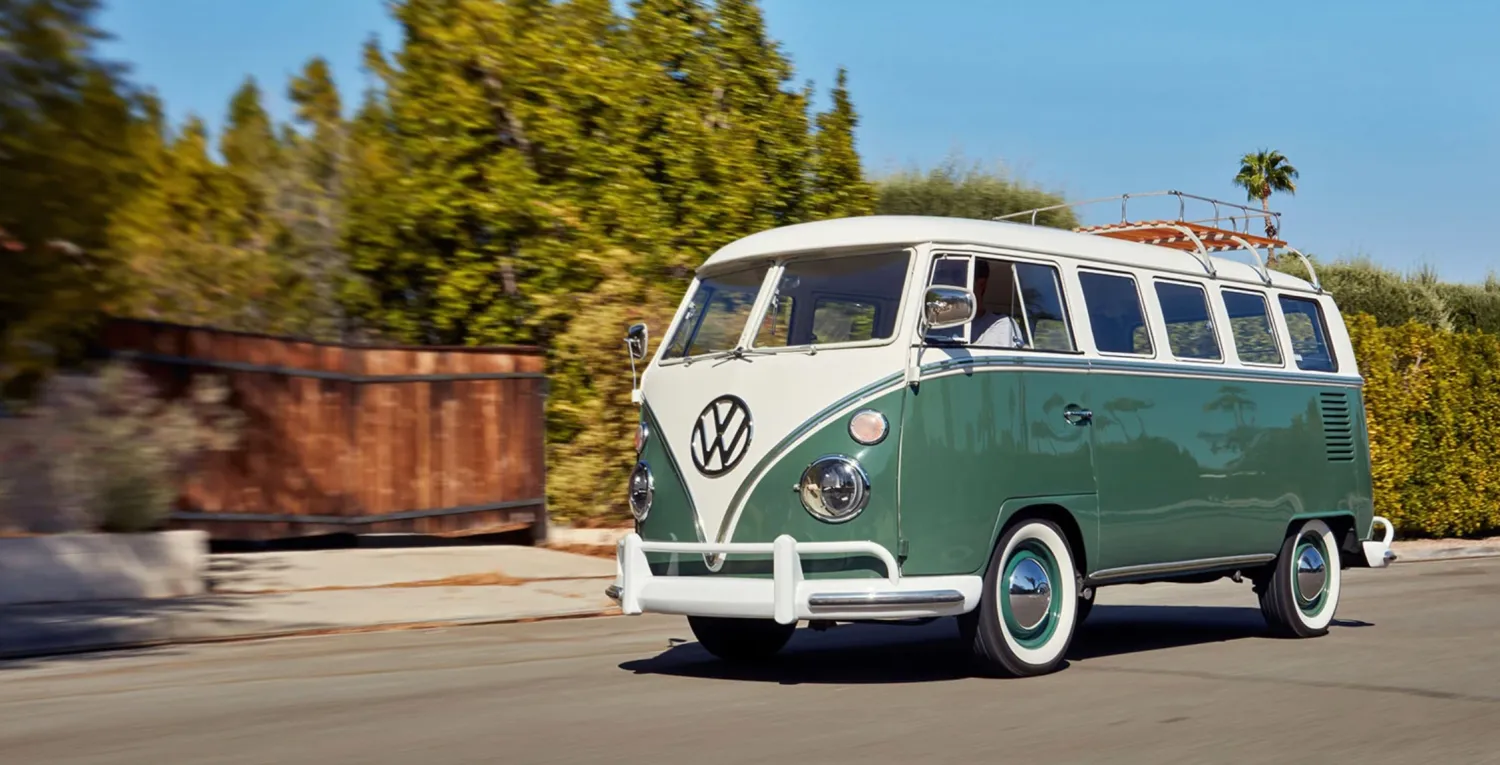 Iconic VW Bus parked by a scenic beach, showcasing its timeless design and adventurous spirit.