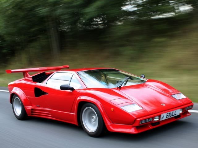 A vibrant red Lamborghini Countach, showcasing its iconic sleek design and distinctive scissor doors.